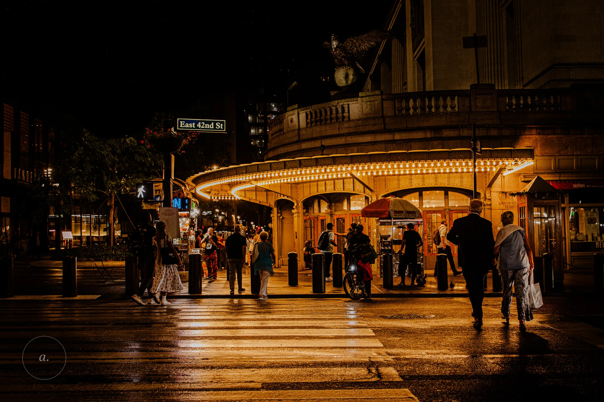 Grand Central Terminal at night, its lit canopy reflected in the wet street on East 42nd, photographed by Campbell Jensen