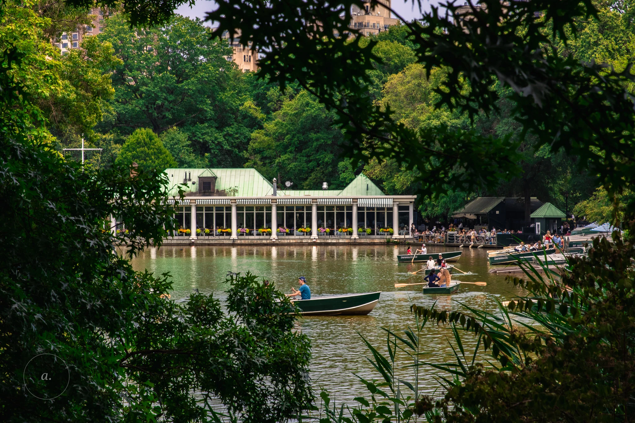 The Loeb Boathouse across the lake in Central Park, rowing boats on the water, photographed by Campbell Jensen